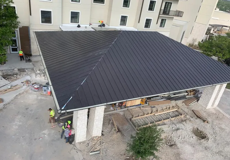 Metal roofing installation team working on a commercial building in Caln